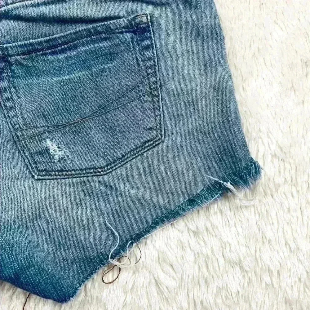 B By‎ Bullhead Med Wash Lowrise Distress Faded Cheeky Raw Hem Jean Shorts Size 9
